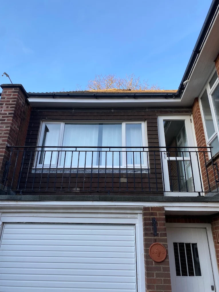 Black exterior cladding and guttering above a local balcony