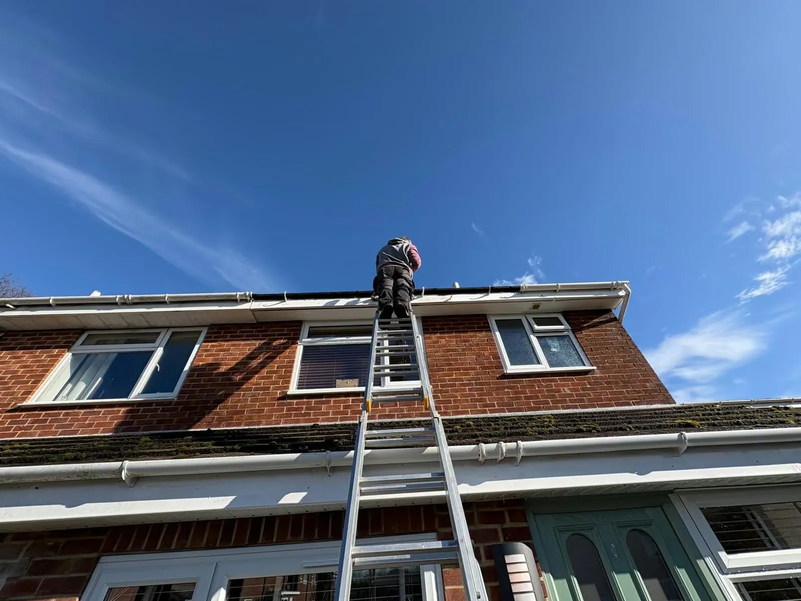 Guttering repair work from a ladder on a local home